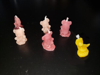 Photo of a bunch of miniature candles; small bears and a snake.