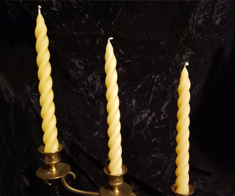 Three swirled natural beeswax tapers representing our tapers and pillar candles collection.